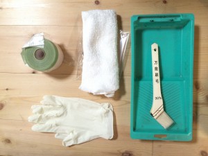 今回、使うものです。左の丸いものが養生材。手袋、タオル、ハケ、塗料入れ（緑色）
