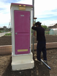 仮設の外トイレが風などで倒されないように杭を打って固定します