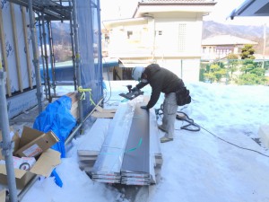 破風板をカット中。地面にある雪にも負けず